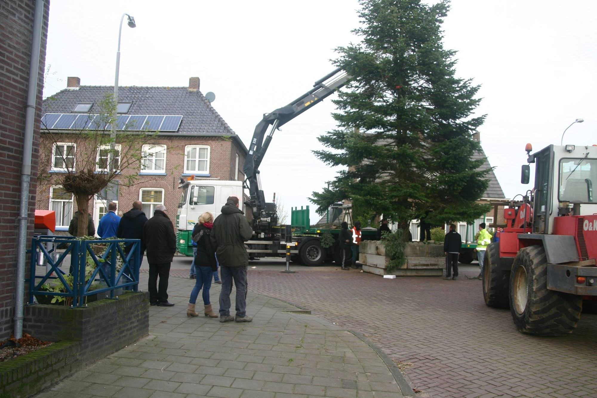 De kerstboom wordt met een kraan in het dorp gezet